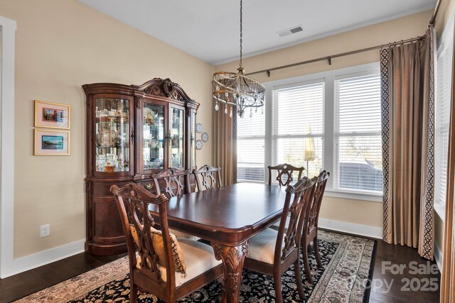 dining area featuring baseboards, visible vents, and dark wood-style flooring