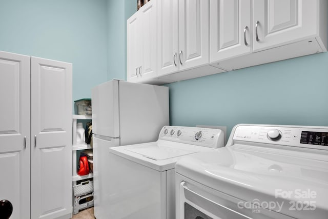 washroom featuring independent washer and dryer and cabinet space