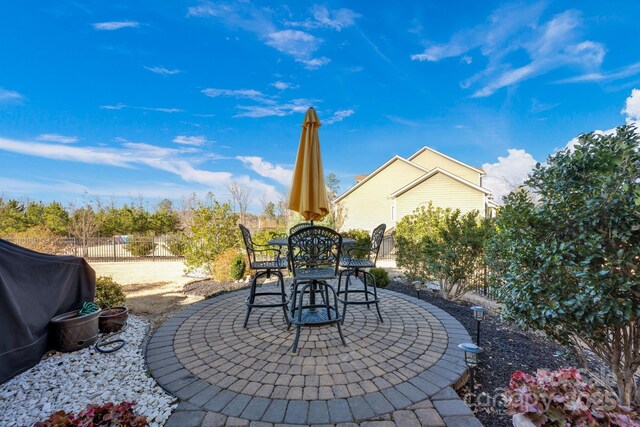 view of patio with a grill and fence