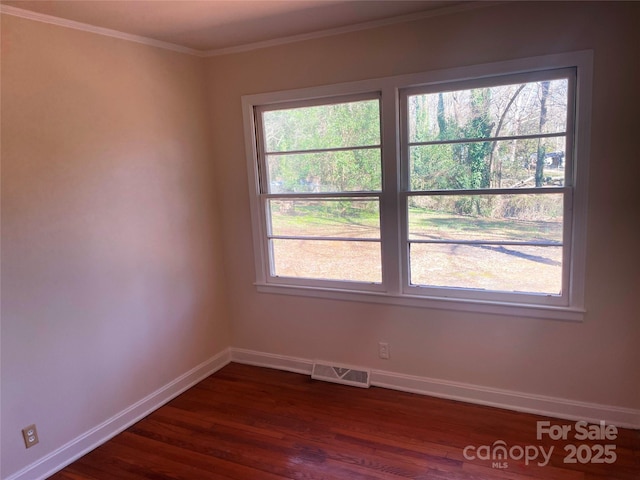 empty room with ornamental molding and dark hardwood / wood-style floors