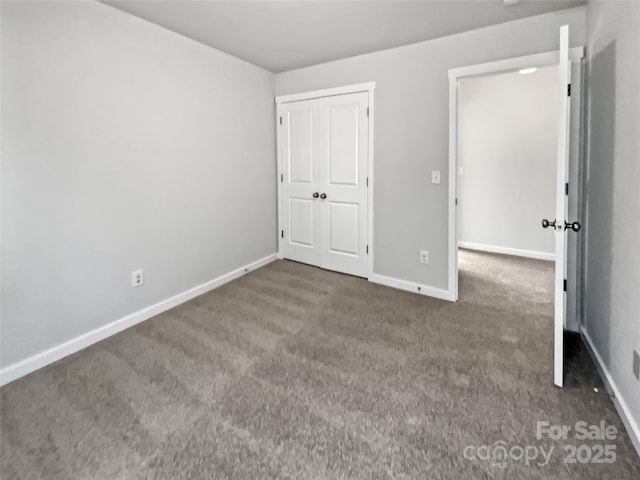 unfurnished bedroom featuring dark colored carpet and a closet