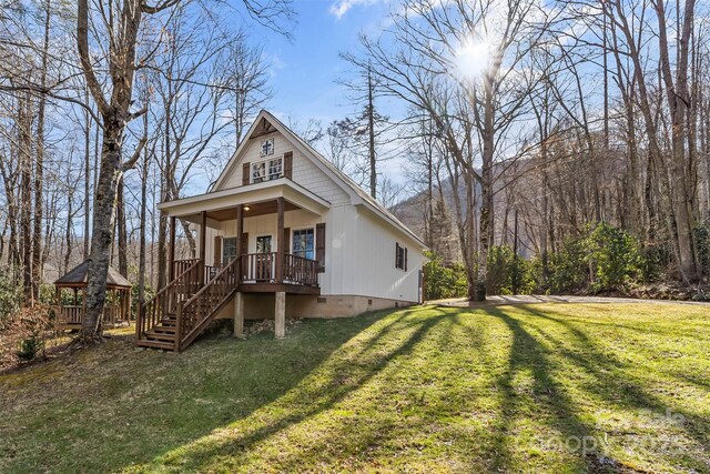 view of front of house featuring a front lawn, crawl space, a gazebo, and stairs