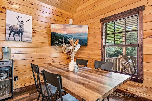 dining room with wood walls, plenty of natural light, and wood finished floors