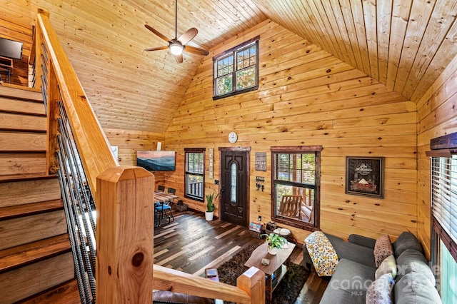 unfurnished living room with wooden ceiling, stairway, wood finished floors, wood walls, and high vaulted ceiling