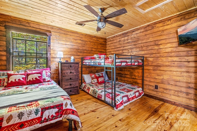 bedroom with a ceiling fan, wood ceiling, log walls, and hardwood / wood-style flooring