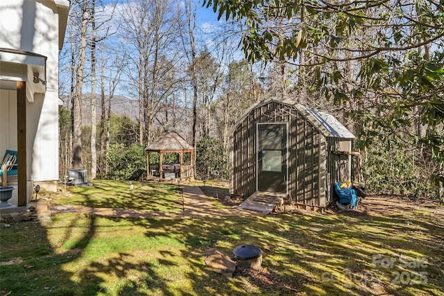 view of yard featuring an outbuilding, a gazebo, a storage unit, and central air condition unit