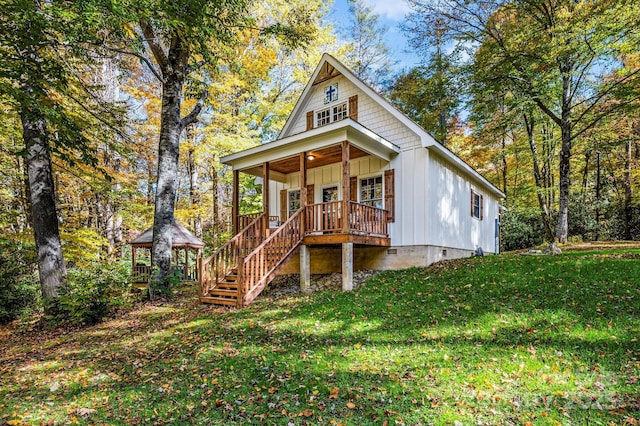 view of front of house featuring covered porch, a gazebo, board and batten siding, a front yard, and crawl space