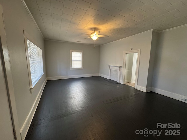 empty room with dark wood-style floors, crown molding, baseboards, and ceiling fan