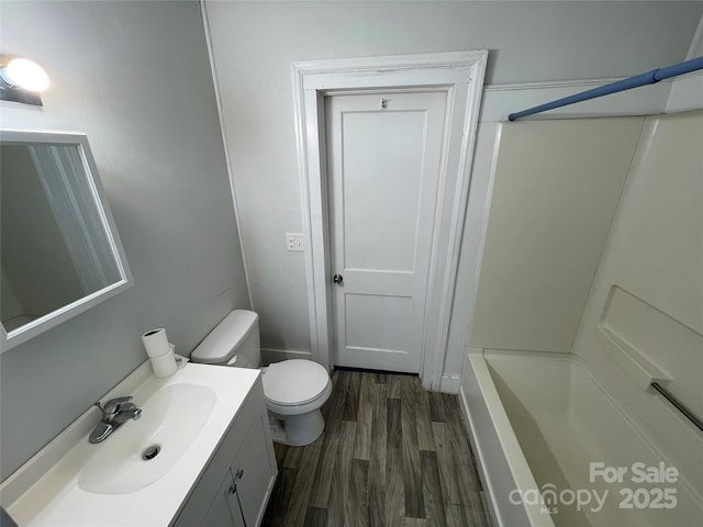 full bathroom featuring toilet, walk in shower, wood finished floors, and vanity