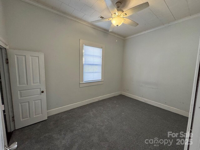 unfurnished bedroom with ornamental molding, dark carpet, baseboards, and ceiling fan