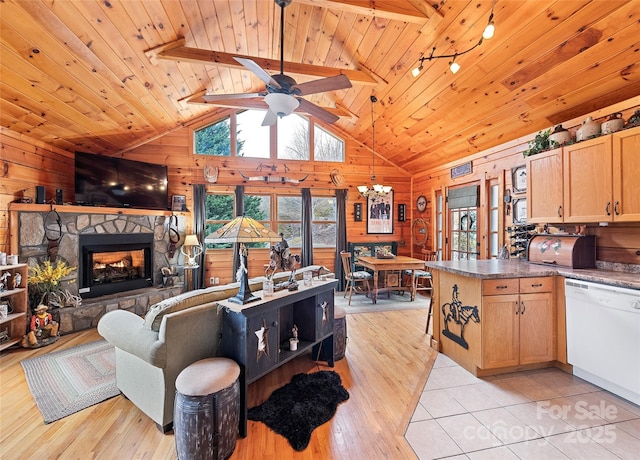 living area featuring wooden walls, light wood finished floors, a stone fireplace, wooden ceiling, and ceiling fan with notable chandelier