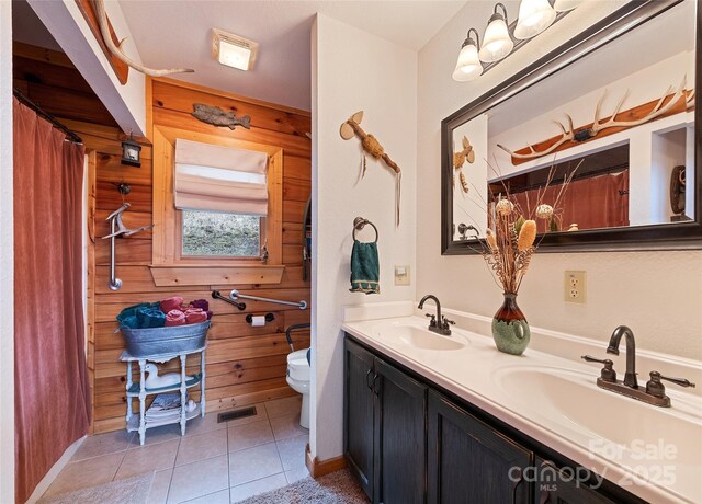 bathroom with tile patterned flooring, visible vents, toilet, and a sink