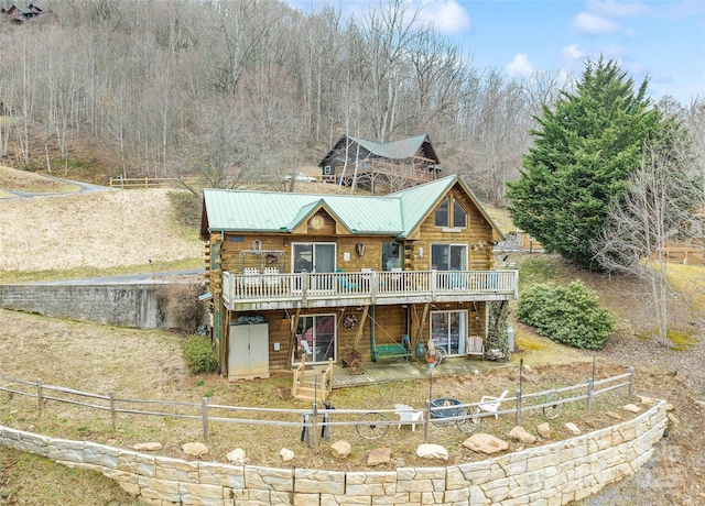 log home with a patio, fence, a wooden deck, metal roof, and log exterior