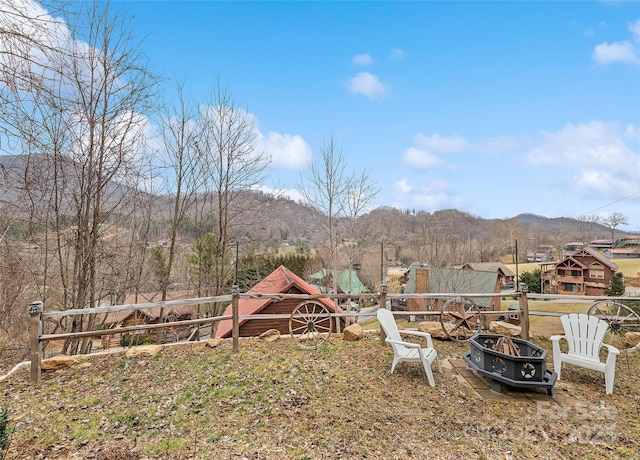 view of yard featuring a mountain view and an outdoor fire pit