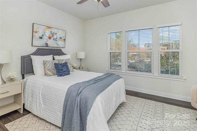 bedroom featuring wood finished floors, a ceiling fan, and baseboards