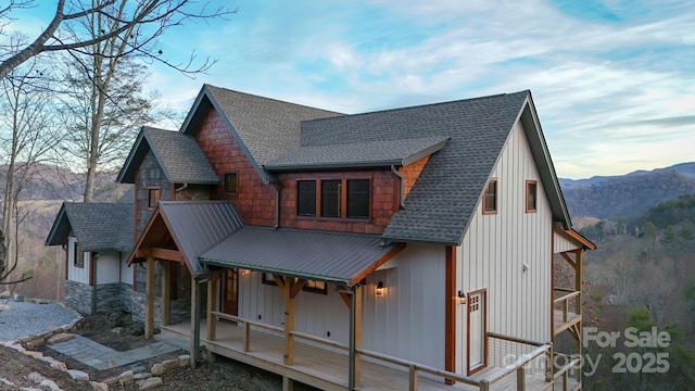 exterior space featuring metal roof, a mountain view, a porch, and roof with shingles