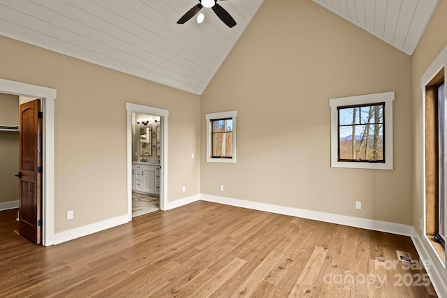 unfurnished bedroom featuring light wood-style floors, a spacious closet, and multiple windows