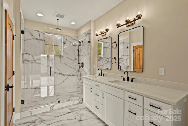 full bathroom featuring marble finish floor, plenty of natural light, and a sink