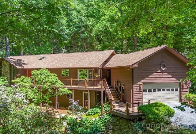 view of front of property featuring stairs, a deck, and roof with shingles