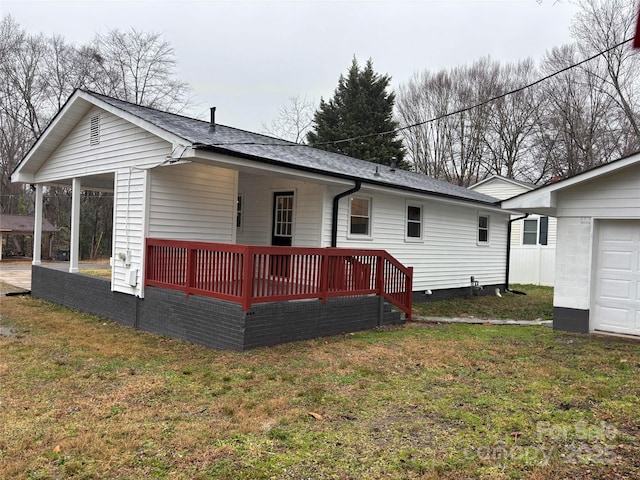 rear view of property featuring a lawn and a deck