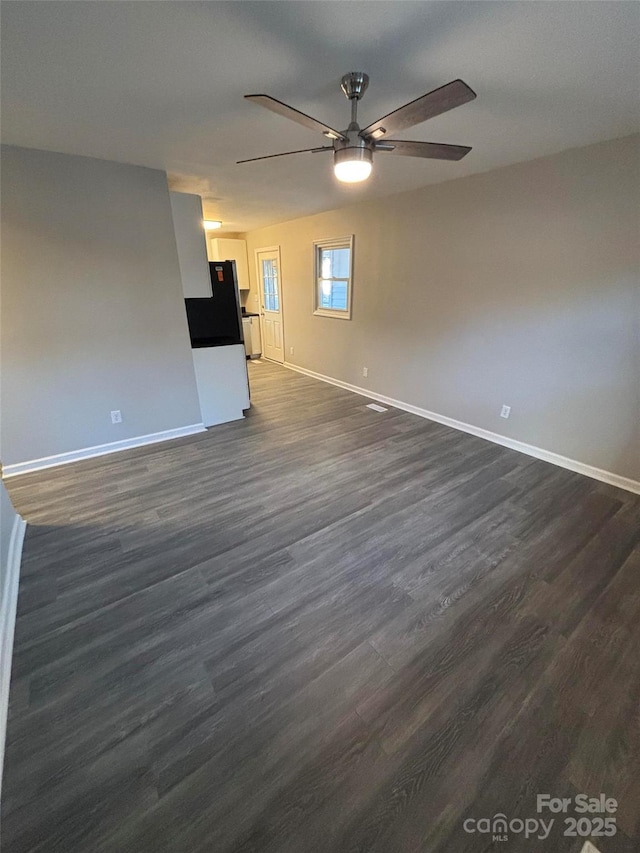 unfurnished living room with ceiling fan and dark wood-type flooring