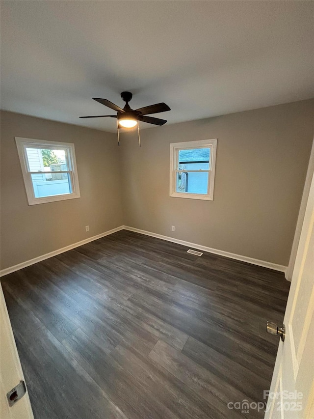 spare room with ceiling fan and dark hardwood / wood-style floors