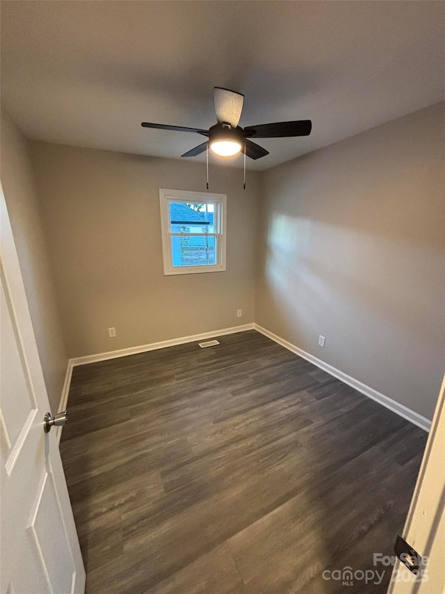 empty room featuring ceiling fan and dark hardwood / wood-style floors