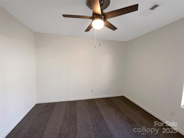 unfurnished room with ceiling fan, visible vents, dark colored carpet, and baseboards