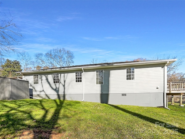 rear view of house featuring crawl space, fence, and a yard