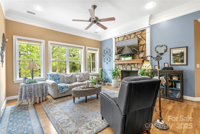 living area featuring light wood-style flooring, visible vents, and crown molding