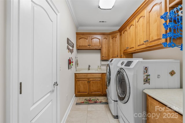 laundry area featuring crown molding, cabinet space, visible vents, a sink, and washer and dryer