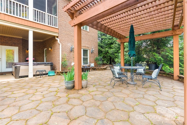 view of patio / terrace with outdoor dining space, a hot tub, and a pergola