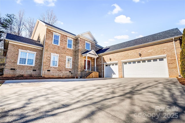 traditional home with driveway, roof with shingles, crawl space, an attached garage, and brick siding