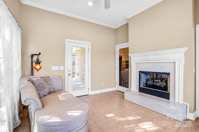 living area featuring light tile patterned flooring, a ceiling fan, a high end fireplace, baseboards, and ornamental molding