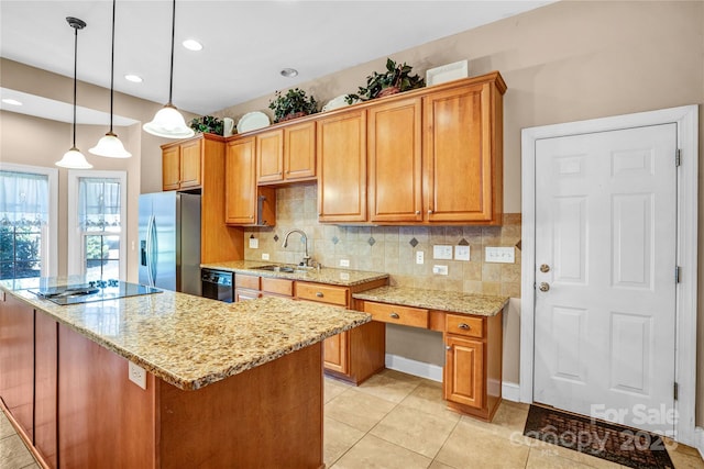 kitchen with light stone counters, pendant lighting, a sink, and black appliances