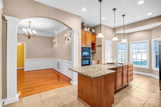 kitchen featuring pendant lighting, light tile patterned floors, a kitchen island with sink, light stone countertops, and black appliances