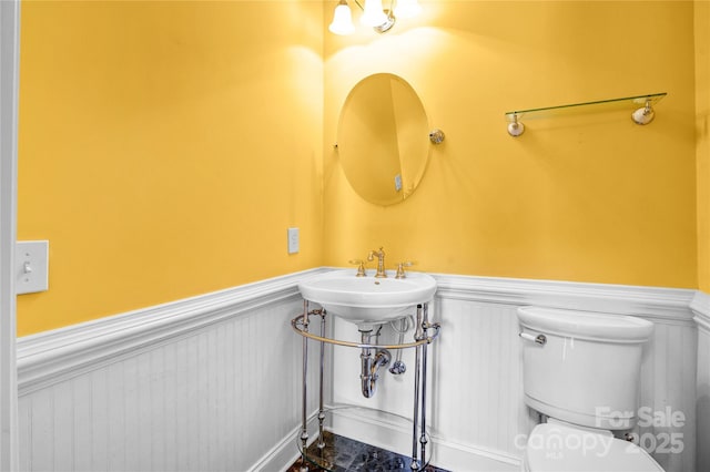 half bath with wainscoting and toilet