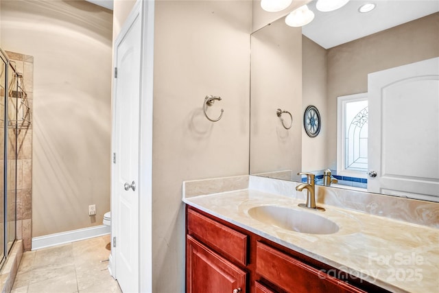 bathroom with toilet, a shower stall, vanity, tile patterned flooring, and baseboards