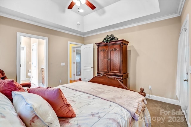 bedroom featuring a tray ceiling, crown molding, light colored carpet, connected bathroom, and baseboards