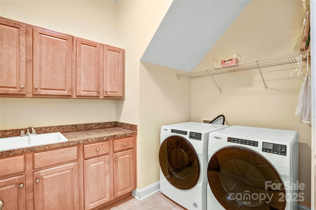 laundry room with light tile patterned flooring, washing machine and dryer, a sink, baseboards, and cabinet space