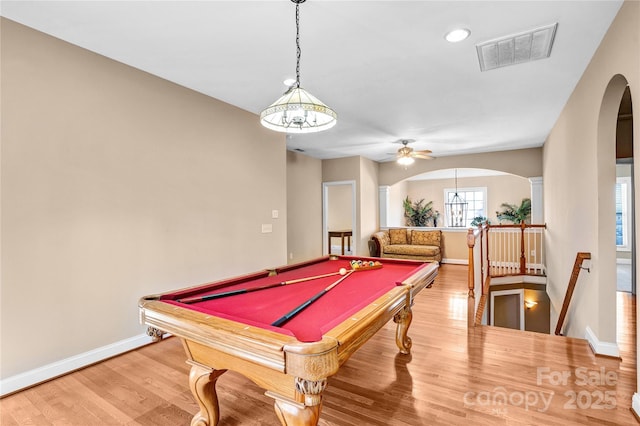 game room featuring arched walkways, wood finished floors, visible vents, and baseboards