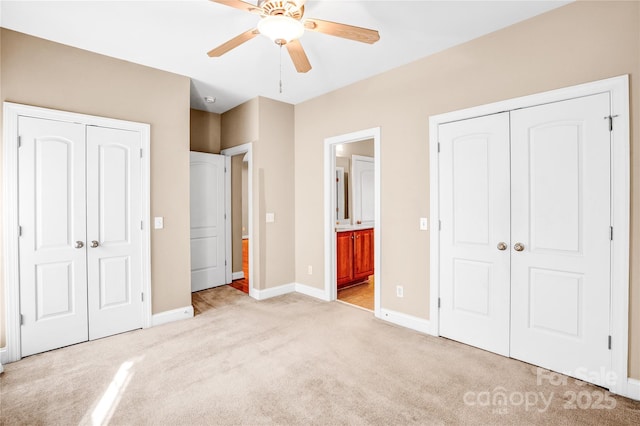 unfurnished bedroom with multiple closets, a ceiling fan, light carpet, connected bathroom, and baseboards