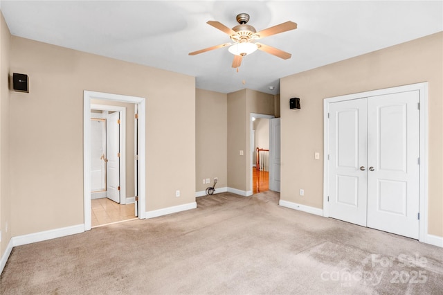 unfurnished bedroom with a closet, light carpet, connected bathroom, and baseboards