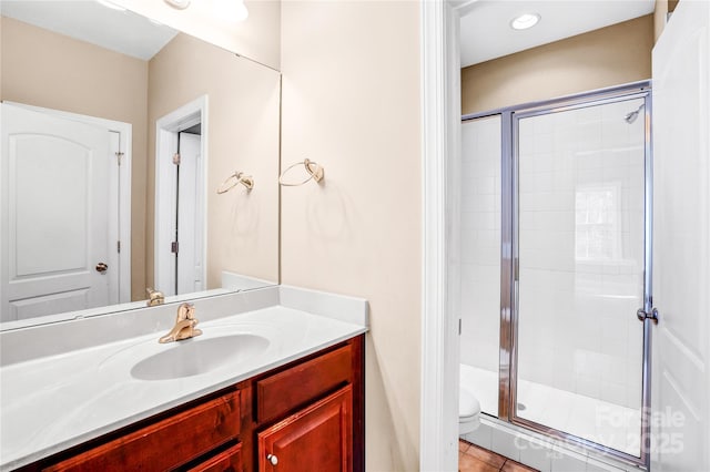 bathroom with toilet, a shower stall, vanity, and tile patterned floors