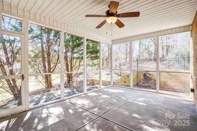 unfurnished sunroom with ceiling fan