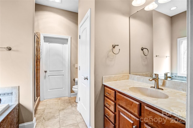 bathroom with a stall shower, vanity, toilet, and tile patterned floors