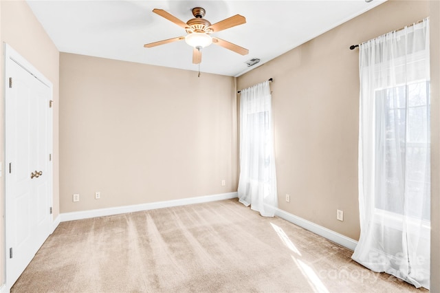 unfurnished room featuring light carpet, ceiling fan, and baseboards