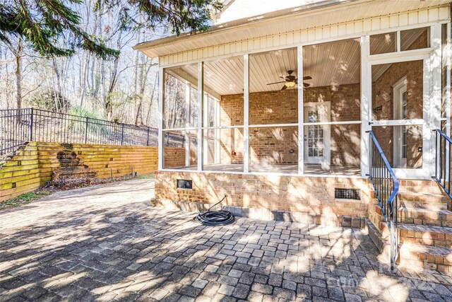 view of patio featuring a sunroom, ceiling fan, and fence