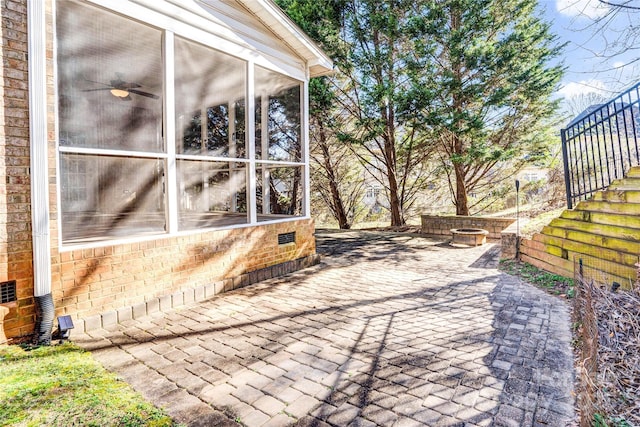 view of patio with ceiling fan, stairway, and a sunroom