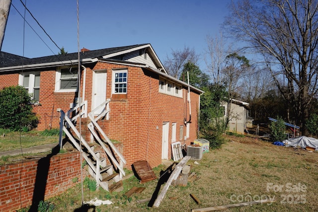 view of home's exterior with a lawn and central AC unit